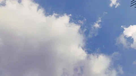 Fluffy white clouds drift across vibrant blue sky, scenic nature background.. Stock Footage 345424452
