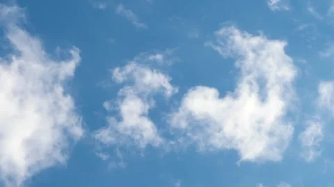Fluffy white clouds drift lazily in a vivid blue sky Vidéo 273516849