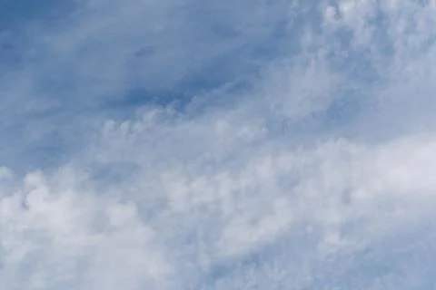 Fluffy white clouds drift peacefully across a bright clear blue sky during .. Photos