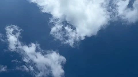Fluffy white clouds drifting across a vibrant blue sky on a clear sunny day Vidéo 339369051