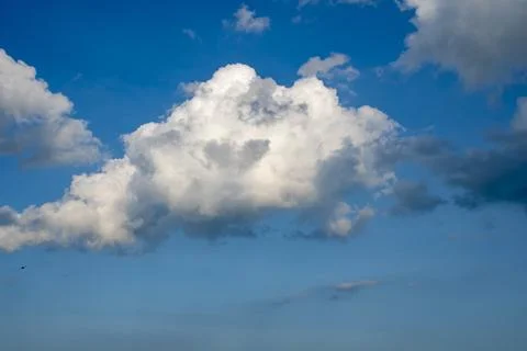 Fluffy White Clouds Drifting Across a Bright Blue Sky in Midday Sun 스톡 사진