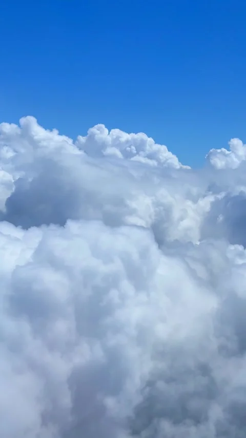 Fluffy White Clouds Floating in Blue Sky Seen from Above on a Sunny Day Stock Footage 310210023