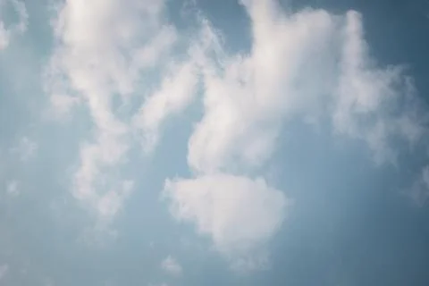 Fluffy white clouds floating in a bright blue sky Stock Photos