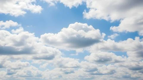 Fluffy white clouds floating in a bright blue summer sky during the day Fotos de archivo
