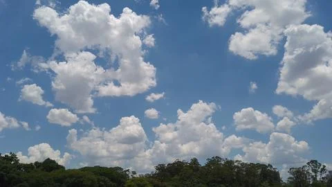 Fluffy white clouds floating in a bright blue summer sky Foto stock