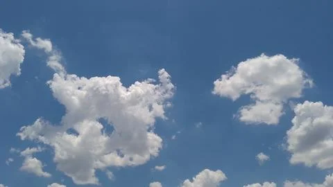 Fluffy white clouds floating in a bright vibrant blue sky Photos