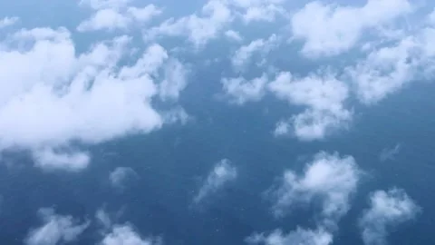 Fluffy white clouds floating over the ocean seen from an aerial view on a calm d Stock Footage 285655507