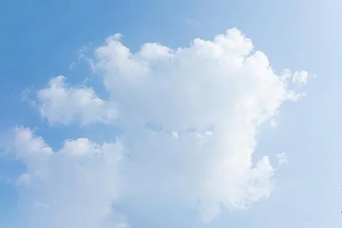 Fluffy white clouds floating peacefully across a clear bright blue sky Stock-Fotos