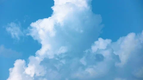 Fluffy white clouds that look like smoke against a clear blue sky. Time laps. Stock Footage 142077746