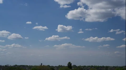 Fluffy white clouds moving across bright blue sky over city horizon Vídeos de archivo 334561796