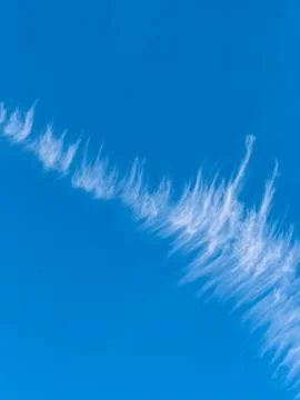 Fluffy white clouds stretch and twist, creating a unique pattern against the  Stock Photos