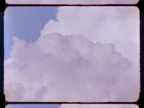 Fluffy white clouds on a sunny day with blue skies - Shot on vintage 16mm film Stock Footage 266279023
