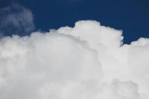 Fluffy white cumulus cloud in a bright blue summer sky background 스톡 사진