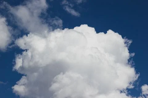 Fluffy white cumulus cloud in a bright blue summer sky background 스톡 사진