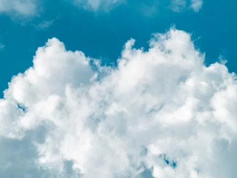 Fluffy white cumulus cloud rising against vivid blue sky, clean minimal wea.. Stock-Fotos