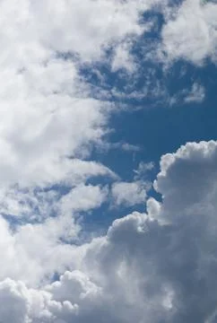 Fluffy white cumulus clouds against a clear blue sky, natural weather background Stock Photos