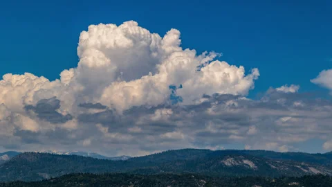 Fluffy White Cumulus Clouds Churn and Boil above Mountains Time Lapse Stock Footage 281474850