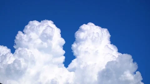 Fluffy white cumulus clouds drifting slowly across a deep clear blue autumn sky Stock-Footage 347038199