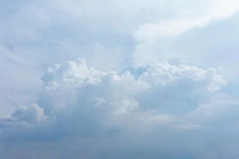 Fluffy white cumulus clouds drifting through a soft blue sky during the day Stock Photos