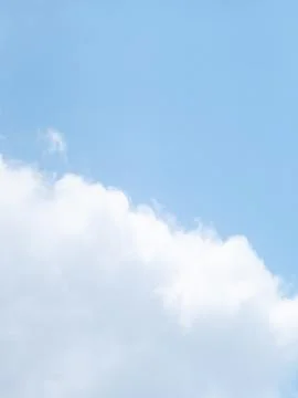 Fluffy White Cumulus Clouds Drifting Across Clear Blue Sky Background 库存照片