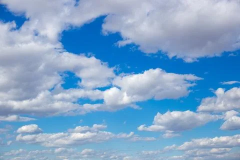 Fluffy white cumulus clouds float across a blue sky, a picturesque celestial Fotos de archivo