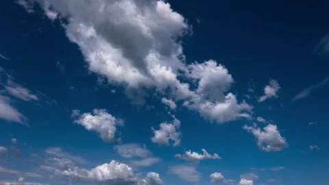 Fluffy White Cumulus Clouds Moving Rapidly Across Bright Deep Blue Sky Stock Footage 335648147