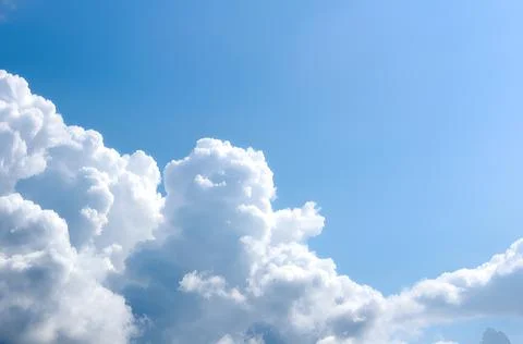 Fluffy white cumulus clouds under a bright blue sky Stock Photos