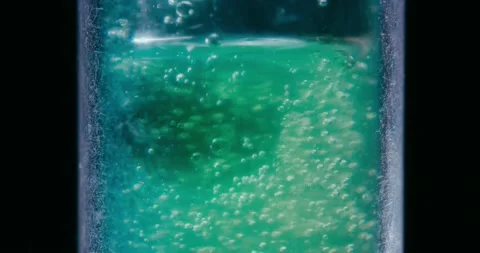 Fluid with bubbles in a vial. black background. Cinematic shot. Stock Footage 237157227