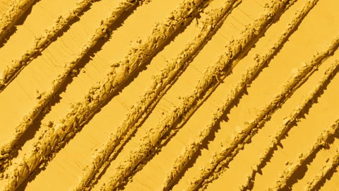 Fluid shifting shadows on yellow powder with knife trails Stock Footage 339384466