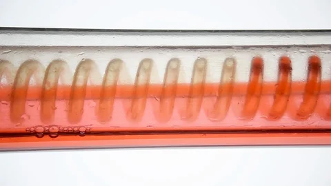 Fluid spiraling horizontally from left to right. Scientific laboratory condenser Stock Footage 123830818