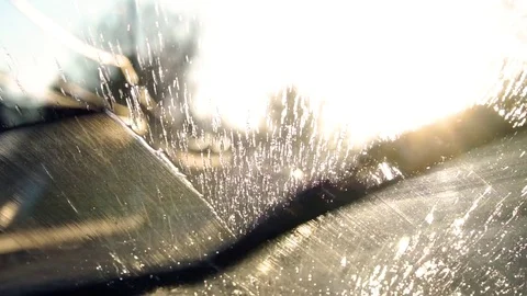 Fluid spraying on a windshield and wipers cleaning it off Stock Footage 77811856