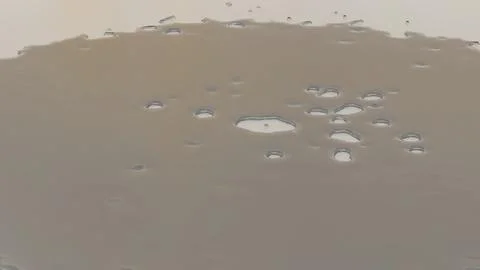Fluid surface with smooth ripples and reflections on a neutral background, .. Stock Photos