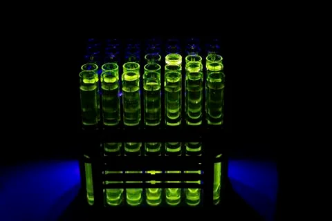 Fluorescent green compound solution collected from column chromatography in m Stock Photos