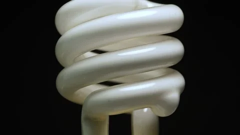 Fluorescent lamp lights close up macro view. Spiral tube bulb rotation on b.. Video stock 271096396