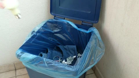 A fluorescent light bulb is thrown into a mixed waste house bin Stock Footage 253185989