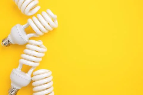 Fluorescent Lightbulbs on a yellow background. Stock Photos