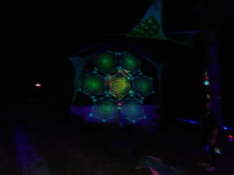 Fluorescent spiderweb pattern installation at night under blacklight Foto stock