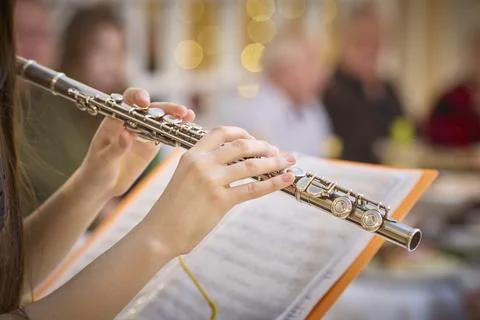 Flute Player Performing at Gathering with Sheet Music Stock Photos