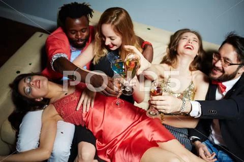 Flutes with champagne in hands of ecstatic friends during toast Stock Photos