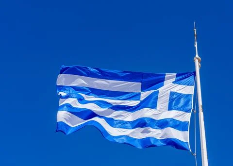Fluttering in the wind Flag of Greece on the ship floats in sea Stock Photos