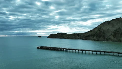 Fly aloft on foreboding autumnal day over Tolaga Bay Wharf - New Zealand 動画素材 179336731
