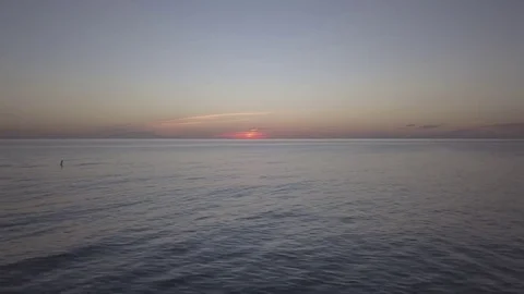 Fly along beach low over the water at sunset Stock Footage 82757461