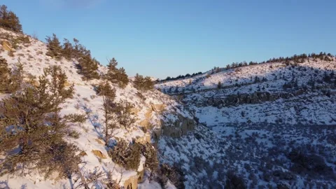 Fly along light snow covered hillside at sunset 스톡 동영상 310574537