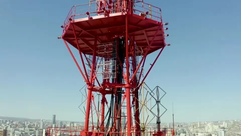 Fly-around around a large area of a large telecommunications tower with view of 스톡 동영상 165349474