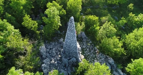 Fly around partisan stone statue totem pyramid on Lubanj Drenova Croatia Stockbeeldmateriaal 75921610