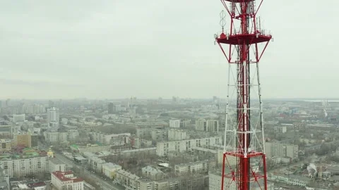 Fly around telecommunications tower with a view of Segapolis, bright sun day Stock Footage 165347604