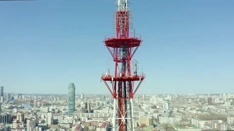 Fly around the telecommunications tower with view of the metropolis, bright sun Stock Footage 165349396