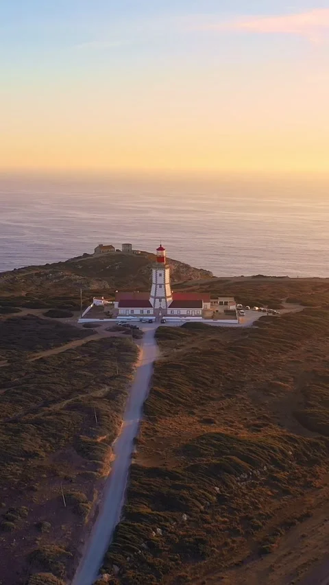 Fly away drone shot of lighthouse, cape Espichel at sunset, Portugal Stock Footage 309025729