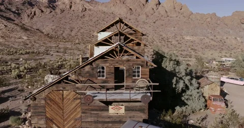 Fly away from large barn in Nelson Nevada western ghost town with a school bus 스톡 동영상 97078233
