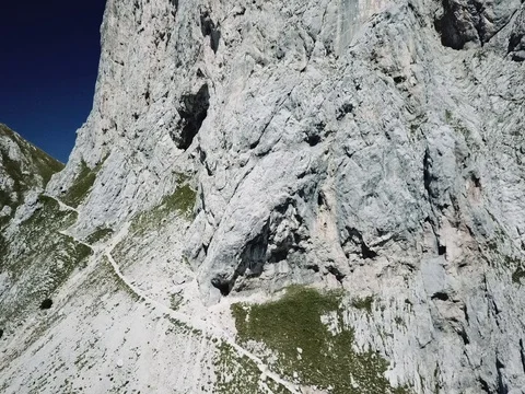Fly away from mountain path with impressive rock formation 2k Stock Footage 83957730